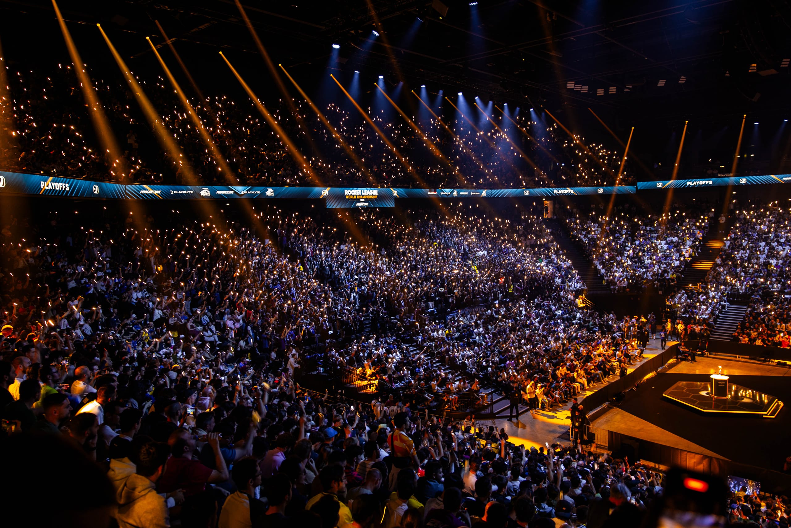 Tribune des Worlds, foule sous les lumières bleues.